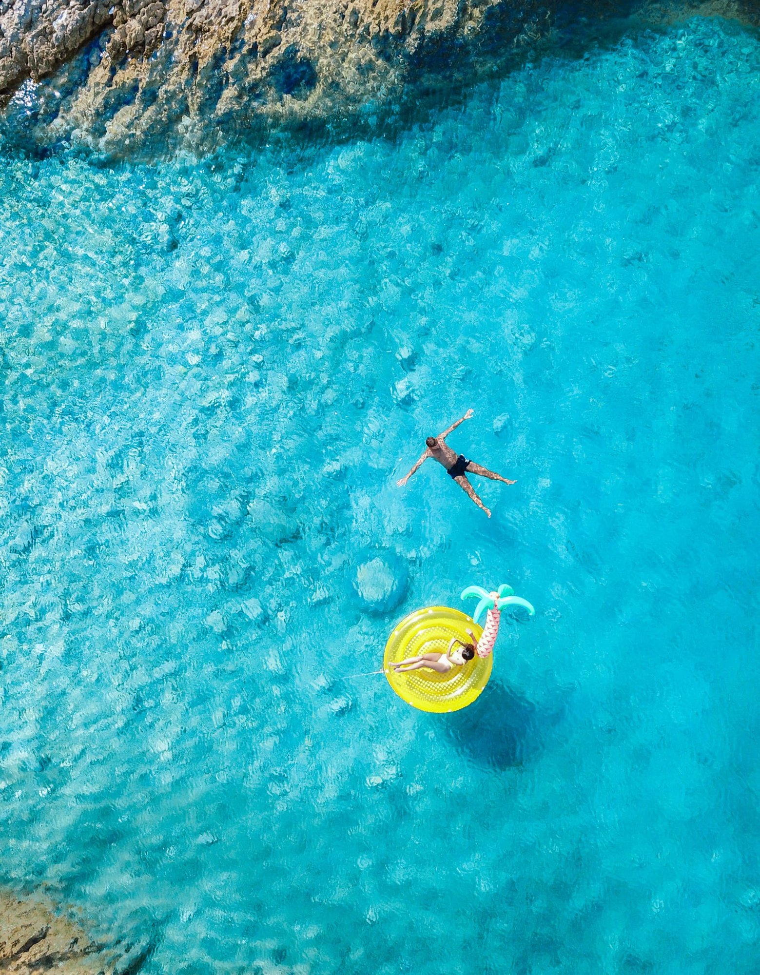 Swimming in a turquoise cove, seen from above