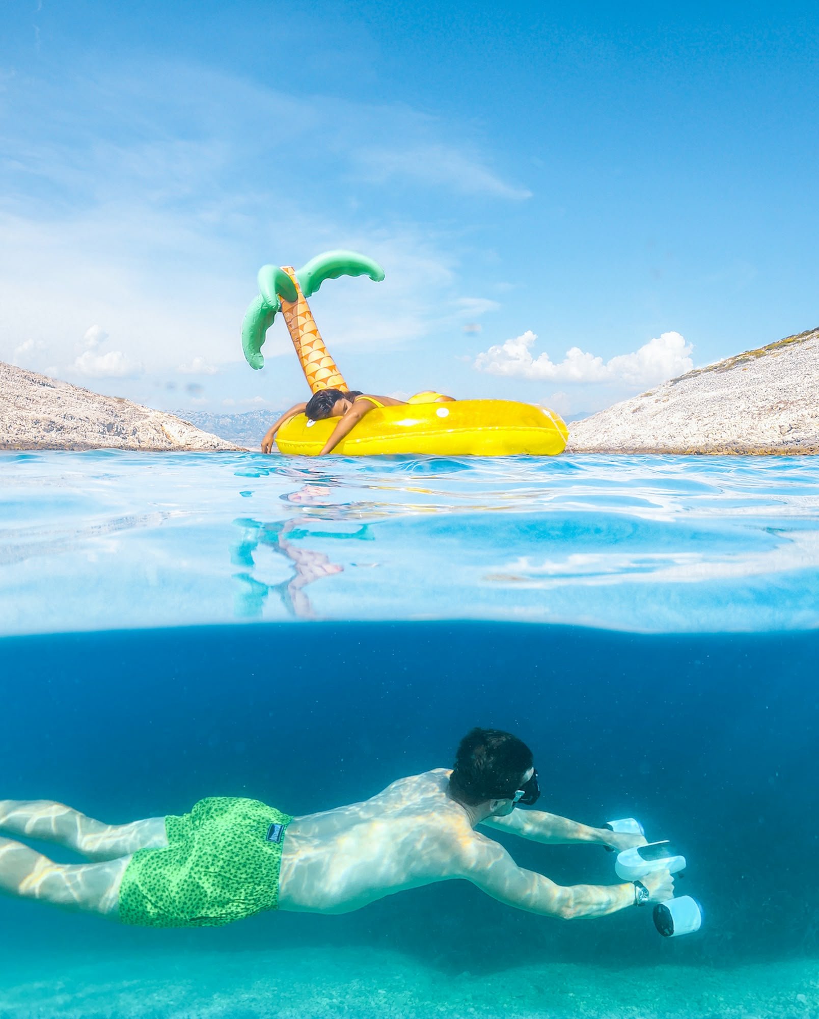 Floating on an inflatable palm island above a snorkeller